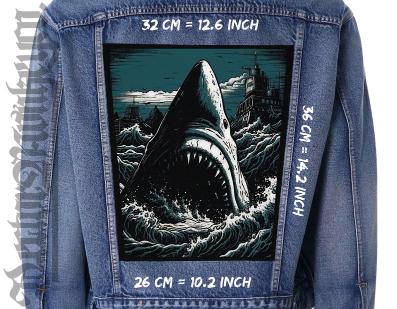 Puede incluir: Una ilustraci&oacute;n en blanco y negro de un tibur&oacute;n con la boca abierta, sobre un fondo azul oscuro con un barco en la distancia. La imagen est&aacute; impresa en un parche de chaqueta vaquera, que mide 32 cm por 36 cm.