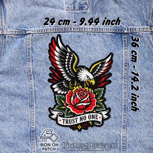 Könnte beinhalten: Ein Aufbügler mit einem Adler-Design, einer roten Rose und einem Banner mit der Aufschrift "TRUST NO ONE". Der Aufnäher ist 24 cm breit und 36 cm hoch. Das Design umfasst Schwarz, Rot, Gelb und Weiß.