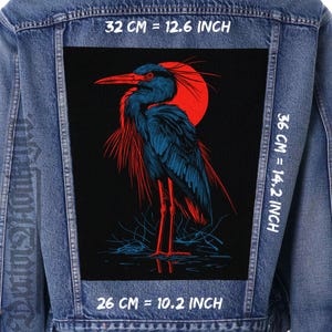 May include: A black and red graphic patch featuring a blue heron standing in water with a red sun in the background. The patch is 12.6 inches wide, 14.2 inches tall, and 10.2 inches deep.