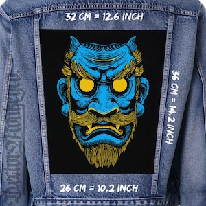 May include: A denim jacket with a large, rectangular patch featuring a blue and yellow Oni mask design. The patch measures 12.6 inches wide by 14.2 inches high (32 cm x 36 cm). The bottom of the patch is 10.2 inches (26 cm) wide. The mask has yellow eyes and a yellow beard.