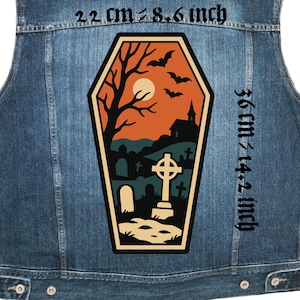 Peut inclure: Un gilet en jean avec un écusson en forme de cercueil représentant une scène de cimetière. L'écusson comprend une croix, des pierres tombales, une église, des chauves-souris et un arbre sur fond orange et bleu. L'écusson mesure environ 22 cm de large et 36 cm de haut.