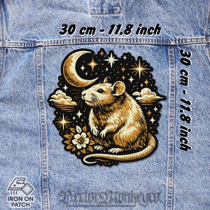 Peut inclure: Un écusson thermocollant avec une illustration détaillée d'un rat, d'un croissant de lune, d'étoiles et de nuages sur fond noir. Le patch mesure 30 cm (11,8 pouces) de diamètre, sur une veste en jean.