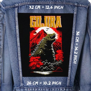 Puede incluir: Un parche bordado negro y rojo con un monstruo parecido a Godzilla con la palabra "Gojira" en letras amarillas. El parche mide 26 cm de ancho, 36 cm de alto y 32 cm de largo.