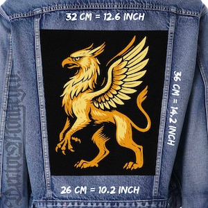 May include: A denim jacket with a large, rectangular patch featuring a golden griffin design on a black background. The patch measures 32 cm by 36 cm, and 26 cm wide. The griffin is a mythical creature with an eagle's head and wings and a lion's body.