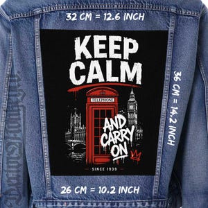 May include: A blue denim jacket featuring a large rectangular back patch with a black background. The patch displays a red telephone booth, Big Ben, and the text KEEP CALM AND CARRY ON SINCE 1939. Dimensions are 12.6 inches wide by 14.2 inches high.