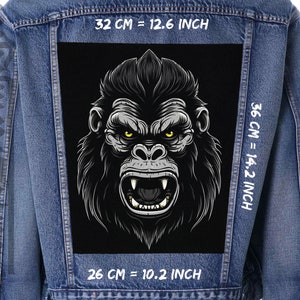 Puede incluir: Una ilustración en blanco y negro de la cara de un gorila con una expresión amenazante. La imagen está impresa en un parche negro y cosida en una chaqueta vaquera azul. El parche mide 32 cm de ancho por 36 cm de alto.