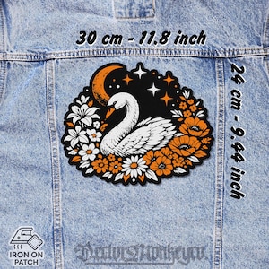 Peut inclure: Un écusson thermocollant avec un cygne entouré de fleurs orange et blanches, d'un croissant de lune et d'étoiles. Le patch mesure 30 cm sur 24 cm. Le texte "Deator Monkeyou" est en bas.