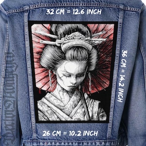 Può includere: Giacca di jeans con una toppa rettangolare raffigurante un'illustrazione di una geisha. La geisha è in bianco e nero con un parasole rosso. La toppa misura 32 cm di larghezza, 36 cm di altezza e 26 cm di lunghezza. Le misure sono anche in pollici.
