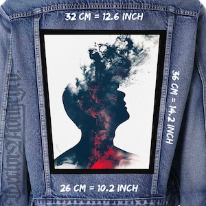 Könnte beinhalten: Jeansjacke mit einem großen rechteckigen Aufnäher. Der Aufnäher zeigt eine Personensilhouette mit roten und schwarzen abstrakten Formen auf weißem Hintergrund. Der Aufnäher misst 32 cm x 36 cm und 26 cm.