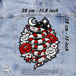 Peut inclure: Écusson thermocollant avec un serpent rouge et blanc enroulé, entouré de fleurs rouges et blanches, d'un croissant de lune et d'étoiles. Mesure 30 cm x 38 cm (11.8 pouces x 15 pouces). Le texte "Iron On Patch" est visible.
