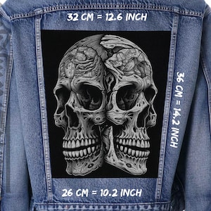 Op de afbeelding: Zwart-witte illustratie van twee schedels met ingewikkelde details, gedrukt op een zwarte stoffen patch. De patch is 32 cm breed, 36 cm hoog en 26 cm diep.