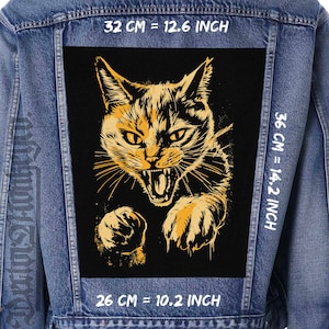 May include: A denim jacket with a large, black patch featuring a detailed illustration of an angry cat. The cat is depicted in shades of yellow and orange, with its mouth open in a snarl. The patch measures 12.6 inches by 14.2 inches.