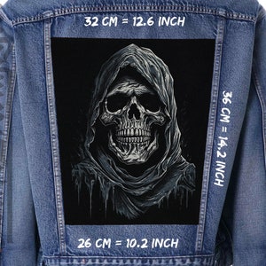 Könnte beinhalten: Ein schwarz-weißer Schädel mit einer Kapuze, gedruckt auf einer Jeansjacke. Das Bild ist 32 cm x 36 cm groß, oder 12,6 Zoll x 14,2 Zoll.