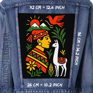 Puede incluir: Chaqueta vaquera con un parche rectangular grande con una ilustración colorida. El parche incluye una figura estilizada, una llama, montañas, un sol y un pájaro. El parche mide 32 cm por 36 cm.