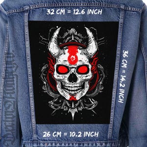May include: A denim jacket with a large, black patch featuring a detailed white skull with red accents. The patch measures 32 cm by 36 cm and 26 cm. The skull has horns and glowing red eyes, creating a striking visual.