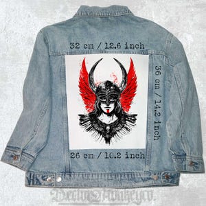 May include: A denim jacket with a patch of a woman wearing a helmet with red wings and a mask. The patch measures 14.2 inches by 10.2 inches.