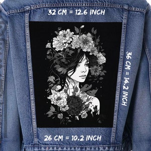 Könnte beinhalten: Eine Schwarzweißillustration einer Frau mit Blumen im Haar. Das Bild ist auf einer Jeansjacke gedruckt. Die Jacke ist 32 cm breit, 36 cm hoch und 26 cm tief.