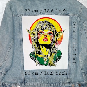 May include: Light blue denim jacket with a large graphic on the back. The graphic features a stylized portrait of a woman with pointed ears, red lips, and green eyes, set against a yellow and red background. The graphic measures 12.6 inches wide and 14.2 inches tall.