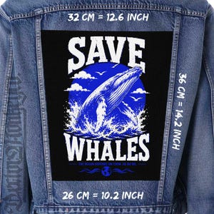 Op de afbeelding: Een blauw spijkerjack met een grote rechthoekige rugpatch op een zwarte achtergrond. De patch toont een witte en blauwe walvis die uit de golven springt, met de tekst SAVE WHALES en THE OCEAN DEPENDS ON THEM. SO DO WE. De afmetingen zijn 32 cm bij 36 cm.