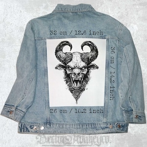May include: A black and white illustration of a horned demon with a menacing expression. The illustration is printed on a white patch, which is attached to a blue denim jacket. The patch measures 14.2 inches by 10.2 inches.