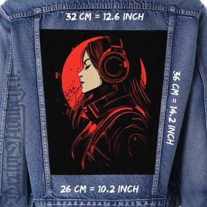 May include: A black and red graphic patch featuring a stylized illustration of a woman wearing headphones. The woman is facing to the left and has long black hair. The background is a red circle with a black outline. The patch is 12.6 inches wide, 14.2 inches tall, and 10.2 inches deep.