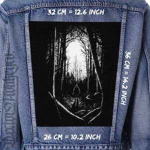 May include: Black and white illustration of a person walking through a dark forest. The image is printed on a black patch with white text that reads "32 CM = 12.6 INCH", "36 CM = 14.2 INCH", and "26 CM = 10.2 INCH".