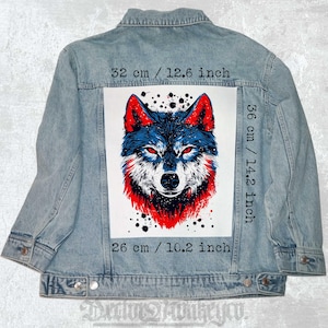 May include: Light blue denim jacket with a large graphic of a wolf on the back. The wolf has red and blue fur and red eyes. The graphic measures 12.6 inches wide and 14.2 inches tall.