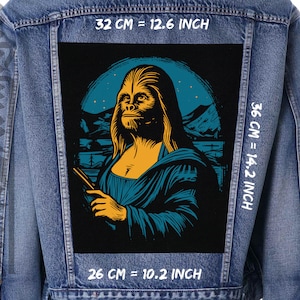 Op de afbeelding: Een spijkerjack met een zwarte patch met een cartoonillustratie van een Chewbacca-achtig wezen in een blauwe en gele Mona Lisa-pose. De patch is 36 cm bij 26 cm, of 14,2 inch bij 10,2 inch.