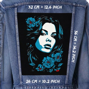 Könnte beinhalten: Eine schwarze Jeansjacke mit einem blauen und weißen Grafik-Patch, das ein Frauen Gesicht mit Blumen zeigt. Der Patch ist 32 cm breit und 36 cm hoch.