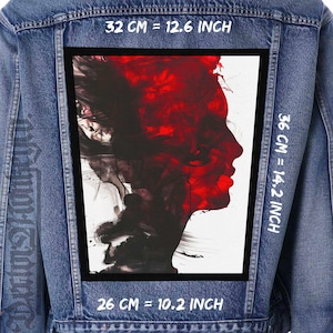 May include: A denim jacket with a large rectangular patch featuring a red and black abstract portrait. The patch measures 12.6 inches by 14.2 inches and 10.2 inches. The portrait is a side profile of a face.