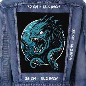 May include: A denim jacket with a large, rectangular patch featuring a teal sea monster design. The monster has sharp teeth and tentacles. The patch measures 12.6 inches wide, 14.2 inches tall, and 10.2 inches across.