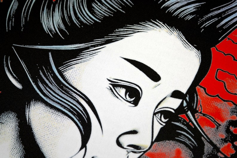 May include: Close-up of a pop art style illustration of a woman's face. The artwork features a black and white colour scheme with red accents. The woman's face is rendered in a comic book style, with bold lines and shading.