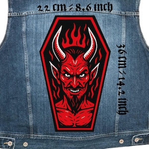Puede incluir: Chaleco vaquero con un parche grande de diablo rojo. El parche, que mide aproximadamente 22 cm por 36 cm, presenta una ilustración detallada de un diablo rojo con cuernos y llamas. El chaleco es de un azul medio.