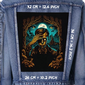Puede incluir: Una chaqueta vaquera con un parche bordado en negro y dorado que representa a un hombre con la mano sobre los ojos, una luna y un castillo espeluznante en el fondo. El parche mide 32 cm de ancho, 36 cm de alto y 26 cm de profundidad.