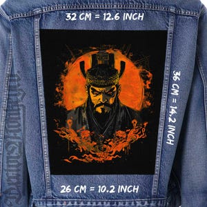 Può includere: Giacca di jeans blu con una grande toppa rettangolare. La toppa raffigura un guerriero dal volto severo con barba e copricapo ornato su sfondo arancione. La toppa misura 32 cm per 36 cm e 26 cm di larghezza. Sono visibili anche fiamme e testo.