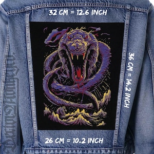 May include: A denim jacket with a large, rectangular patch depicting a purple snake with an open mouth. The patch is 32 cm wide and 36 cm tall. The snake illustration has a detailed design with sharp teeth.