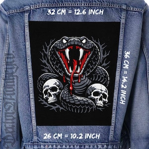 May include: A denim jacket with a large, black patch featuring a detailed illustration of a cobra with its mouth open, fangs bared, and blood dripping. Two skulls are below the snake. The patch measures 32 cm by 36 cm and 26 cm.