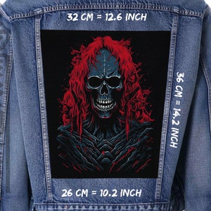 Op de afbeelding: Een spijkerjack met een zwarte patch met een schedel met rood haar op een donkere achtergrond. De patch is 32 cm breed, 36 cm hoog en 26 cm diep.