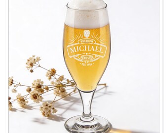 以下が含まれることがあります： 黄金色のビールと分厚い白い泡が入った、背の高い透明なビールグラス。 グラスには、装飾的なラベルで「MICHAEL」という名前が記されており、「PREMIUM」と「GENIESSER」という言葉も含まれています。