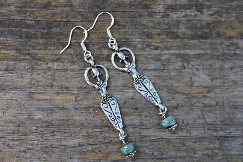 Spiritual earrings with fertility goddess charms and combined with water bleu clay beads