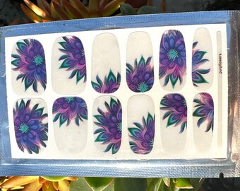 Puede incluir: Pegatinas de arte de uñas con un diseño floral. Las pegatinas tienen un fondo blanco con patrones de flores moradas, turquesas y verdes. El texto "purpflowers" está impreso en el embalaje.