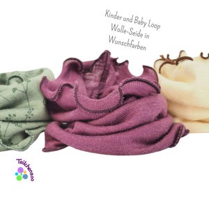 Könnte beinhalten: Drei verschiedene farbige Stoffschlaufen aus Wolle und Seide mit einem gekräuselten Rand. Die Schlaufen sind in den Farben Grün, Lila und Creme. Der Text "Kinder und Baby Loop Wolle-Seide in Wunschfarben" ist im Bild sichtbar.