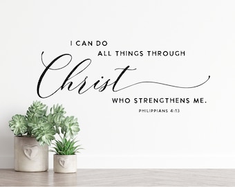 Pode incluir: Uma parede branca com o texto "I CAN DO ALL THINGS THROUGH Christ WHO STRENGTHENS ME. Philippians 4:13" em escrita preta. Duas pequenas suculentas em vasos estão abaixo.