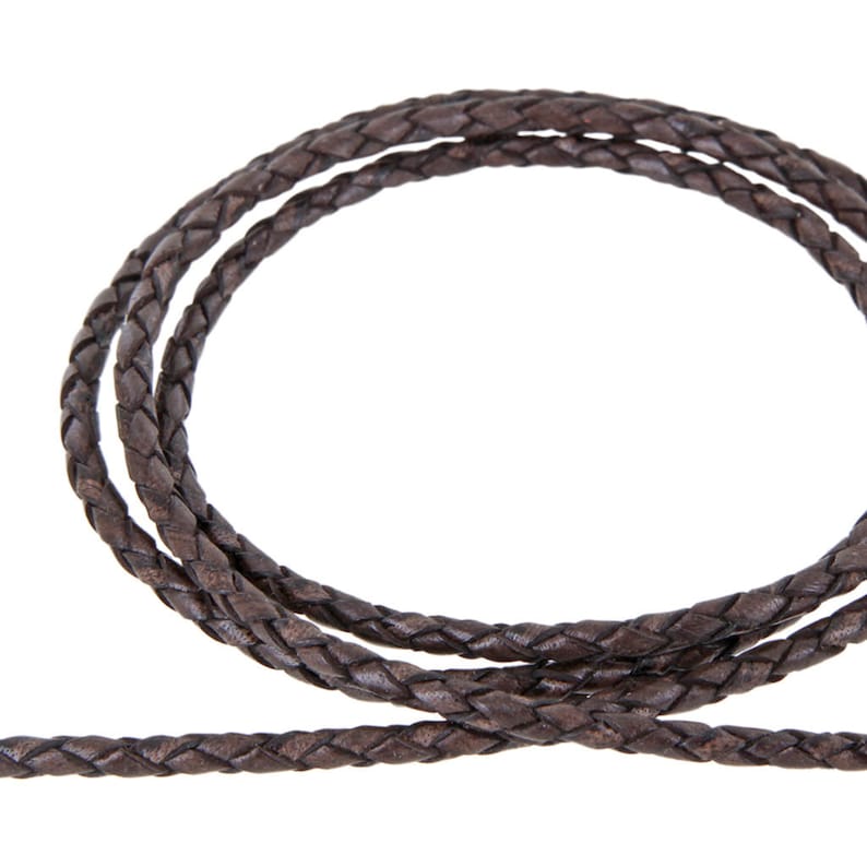 May include: A close-up of a brown braided leather cord. The cord is thick and has a smooth texture.