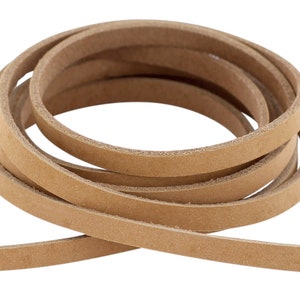 Puede incluir: Un rollo de cordón de cuero marrón claro. El cordón tiene aproximadamente 6 mm de ancho y está enrollado.