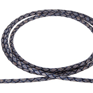 May include: A close-up of a braided leather cord in blue and brown colors. The cord is woven in a tight pattern and is ideal for crafting jewelry or other projects.