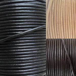 Op de afbeelding: Drie spoelen lederkoord in de kleuren zwart, bruin en naturel. Het koord is glad en heeft een lichte glans.