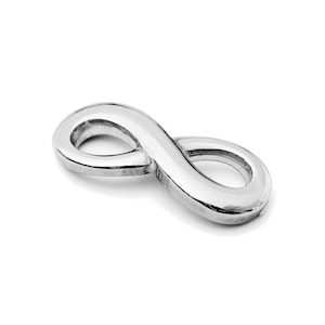 Peut inclure: Un charme en argent en forme de symbole infini. Le charme est lisse et brillant, avec un design simple.