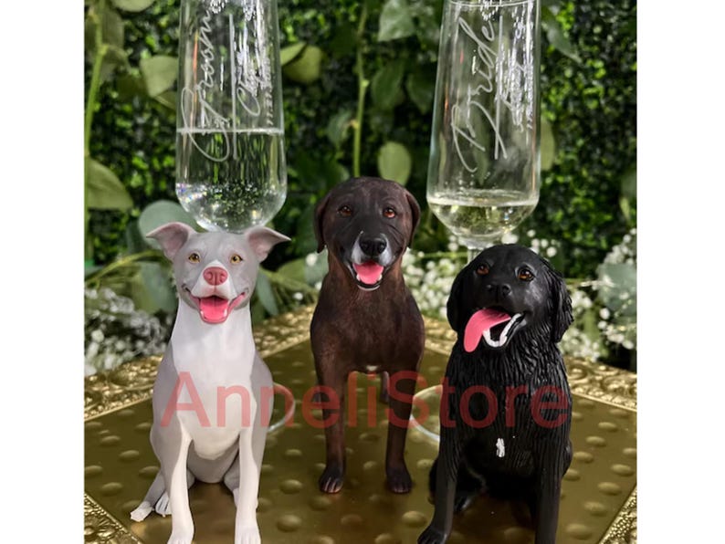 May include: Three dog figurines in gray, brown, and black colors with pink tongues, positioned in front of two clear glass champagne flutes. The left flute is etched with Groom and the right flute is etched with Bride, both featuring script text.