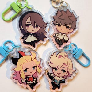 May include: Four colorful anime-style character keychains with clear plastic backgrounds and metal clasps. The characters are a girl with brown hair and a black dress, a boy with brown hair and a white shirt, a girl with pink and blonde hair and a red and black dress, and a boy with blonde hair and a blue shirt.